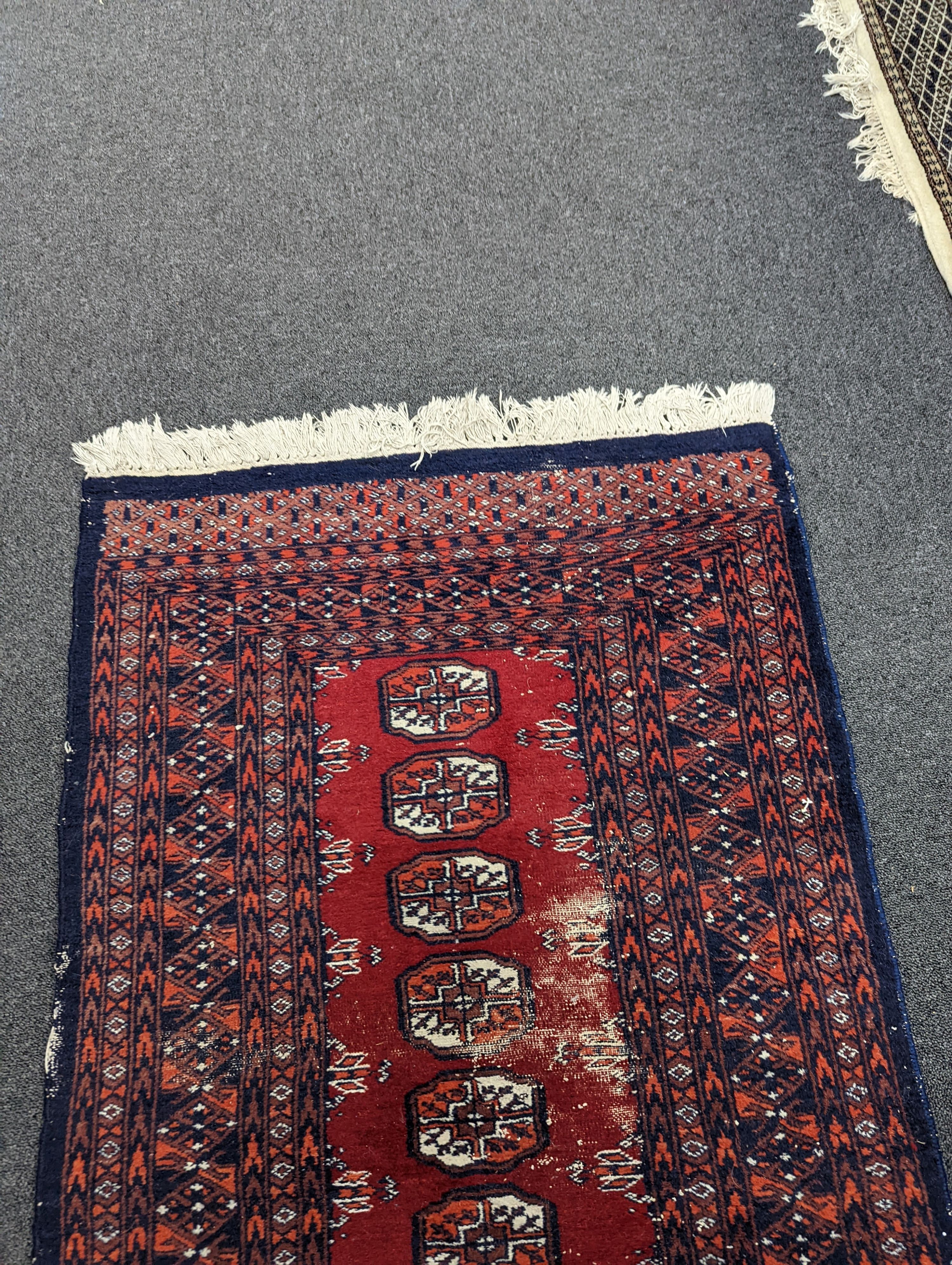 A Caucasian red ground rug and a Bokhara runner, rug 180 x 120 cms